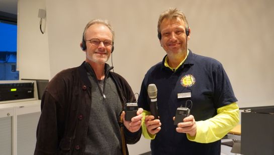 Stefan Schulz-Kiske (links) und Sven Kunze präsentieren die Unterstützungssysteme für Menschen mit Hörbeeinträchtigung und appellieren an die Sitzungsteilnehmenden, die Mikrofone konsequent zu nutzen.