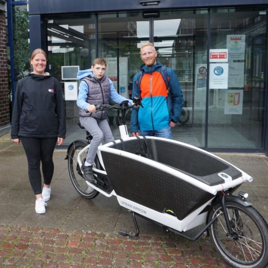 Conner und sein Papa Rainer Jaeger freuen sich gemeinsam mit Mareike Mierau, Mitarbeiterin der Gemeinde auf die zweite inklusive Radtour