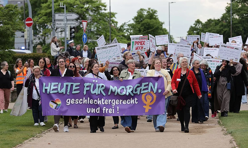 Ein Demonstrationszug von mehreren Frauen, die Plakate zeigen