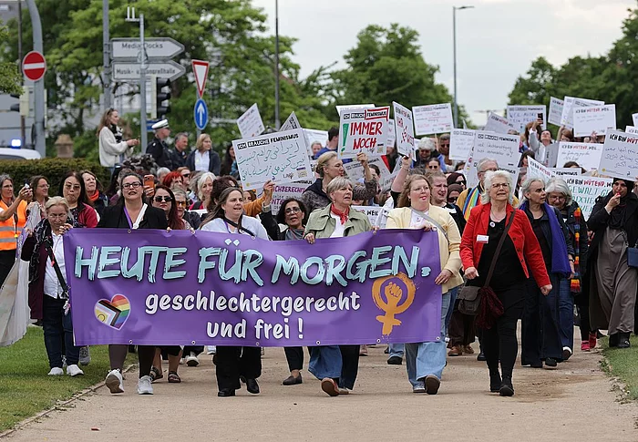 Ein Demonstrationszug von mehreren Frauen, die Plakate zeigen