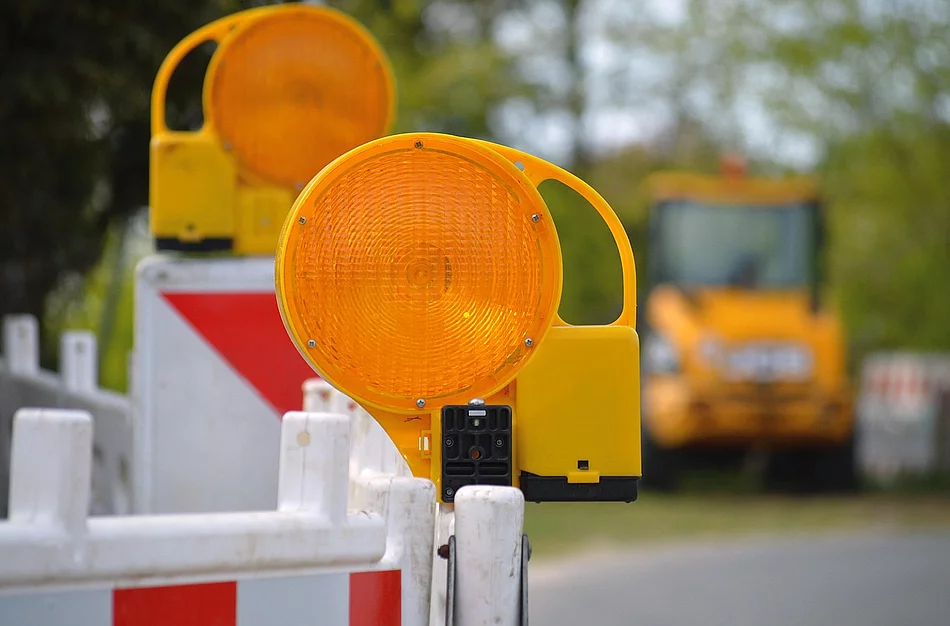 Warnleuchten und Absperrbarken weisen auf eine Straßensperrung hin