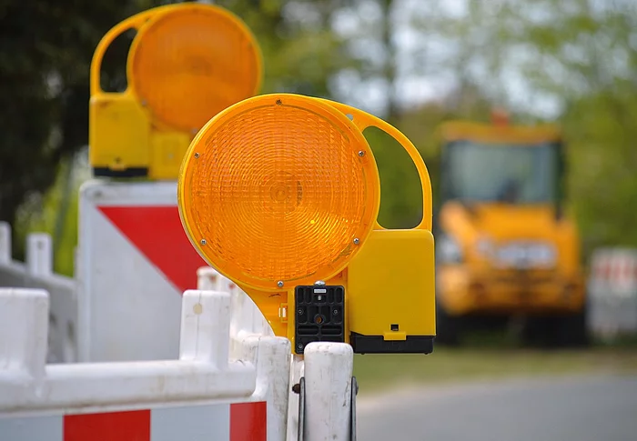 Warnleuchten und Absperrbarken weisen auf eine Straßensperrung hin