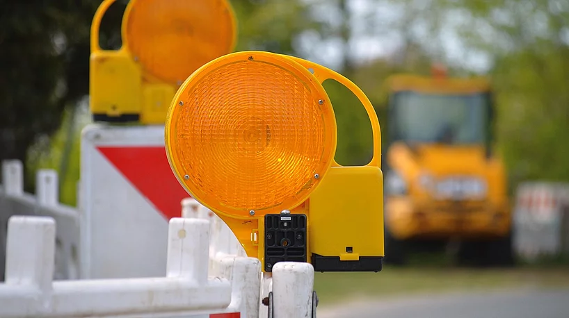 Warnleuchten und Absperrbarken weisen auf eine Straßensperrung hin