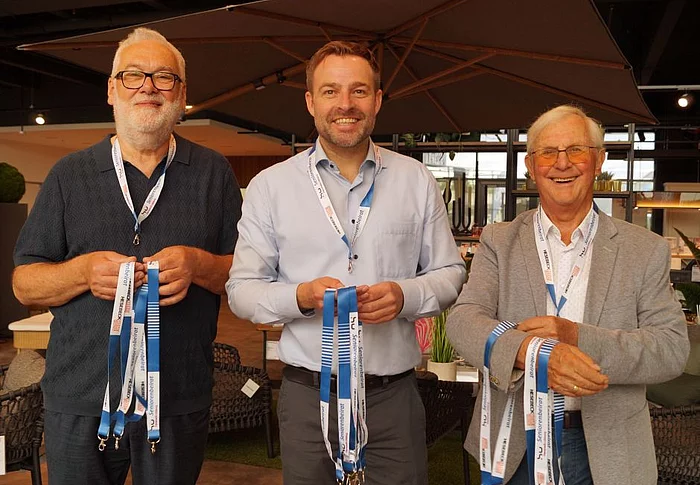 Zwei Personen vom Seniorenbeirat und Bernd Langbehn von Hesebeck Home Company halten Schlüsselbänder in den Händen