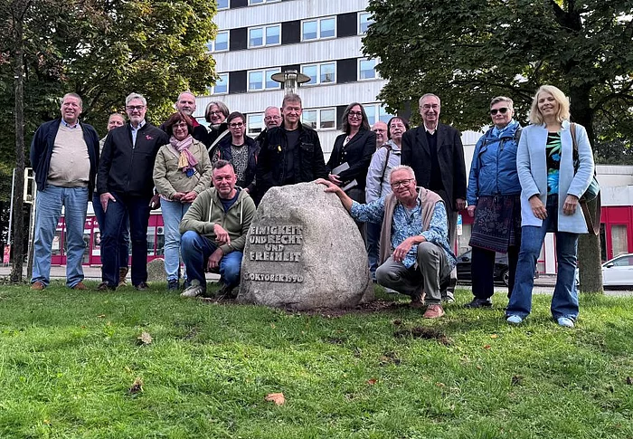 Mehrere Personen stehen um den Einheitsstein