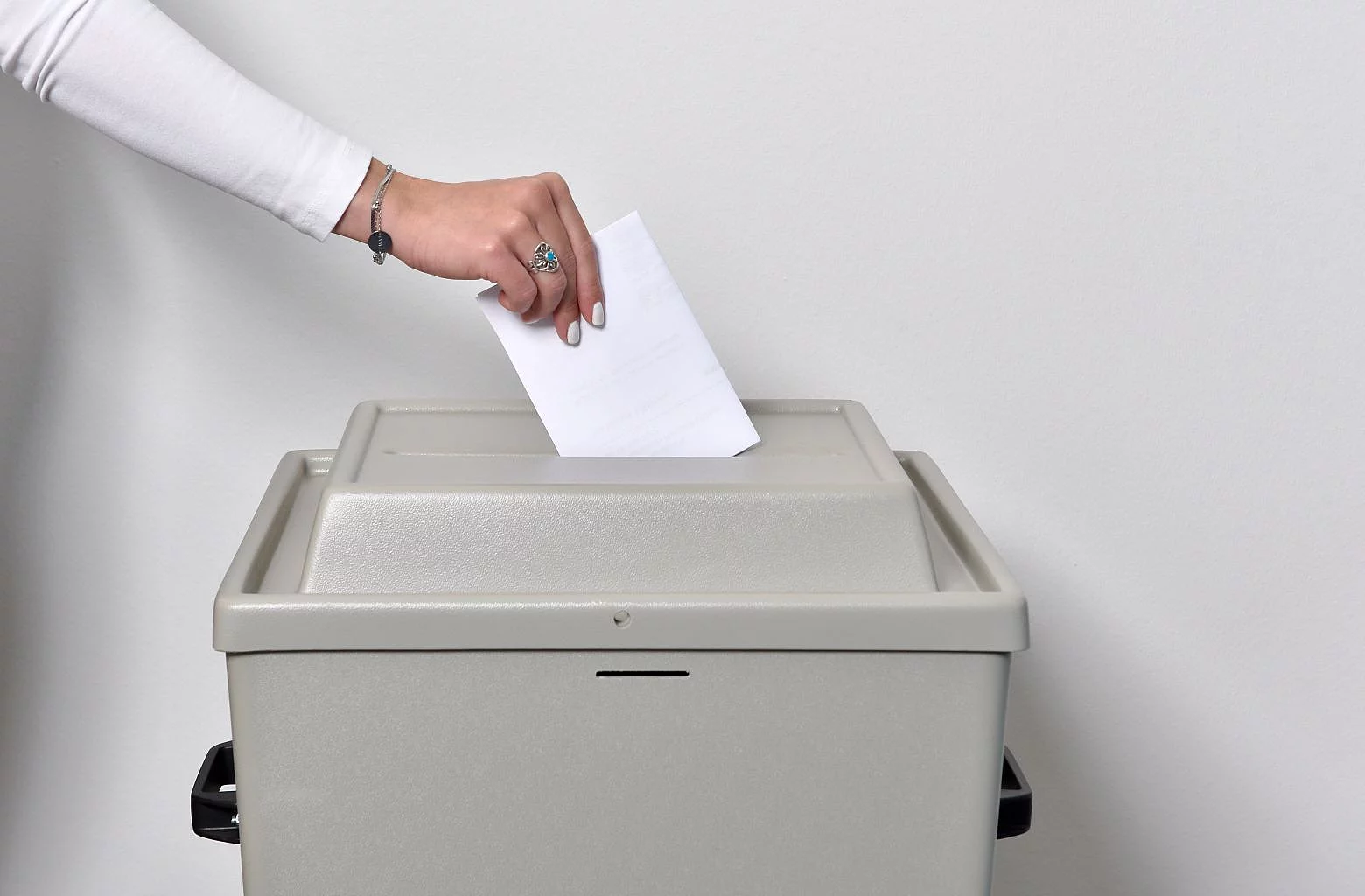 Ein Stimmzettel wird in die Wahlurne geworfen