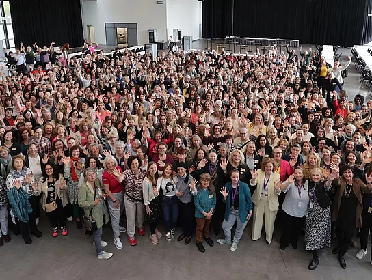 Gruppenfoto aus höherer Perspektive auf dem mehrere Frauen zu sehen sind, die winken