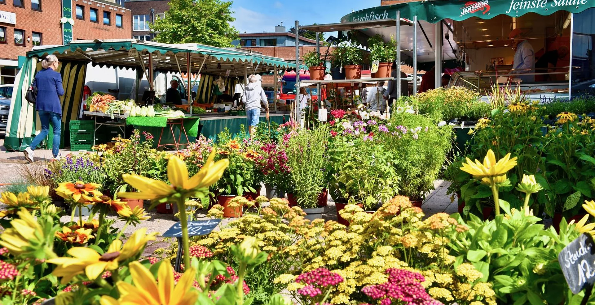 Blick auf den Wochenmarkt Ulzburg mit Blumen im Vordergrund