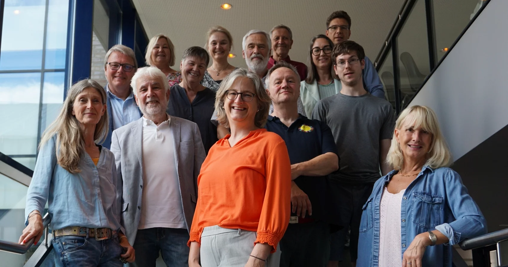 Die Akteure der Steuerungsgruppe Inklusion stehen zusammen auf einer Treppe im Rathaus der Gemeinde und schauen freundlich in die Kamera.